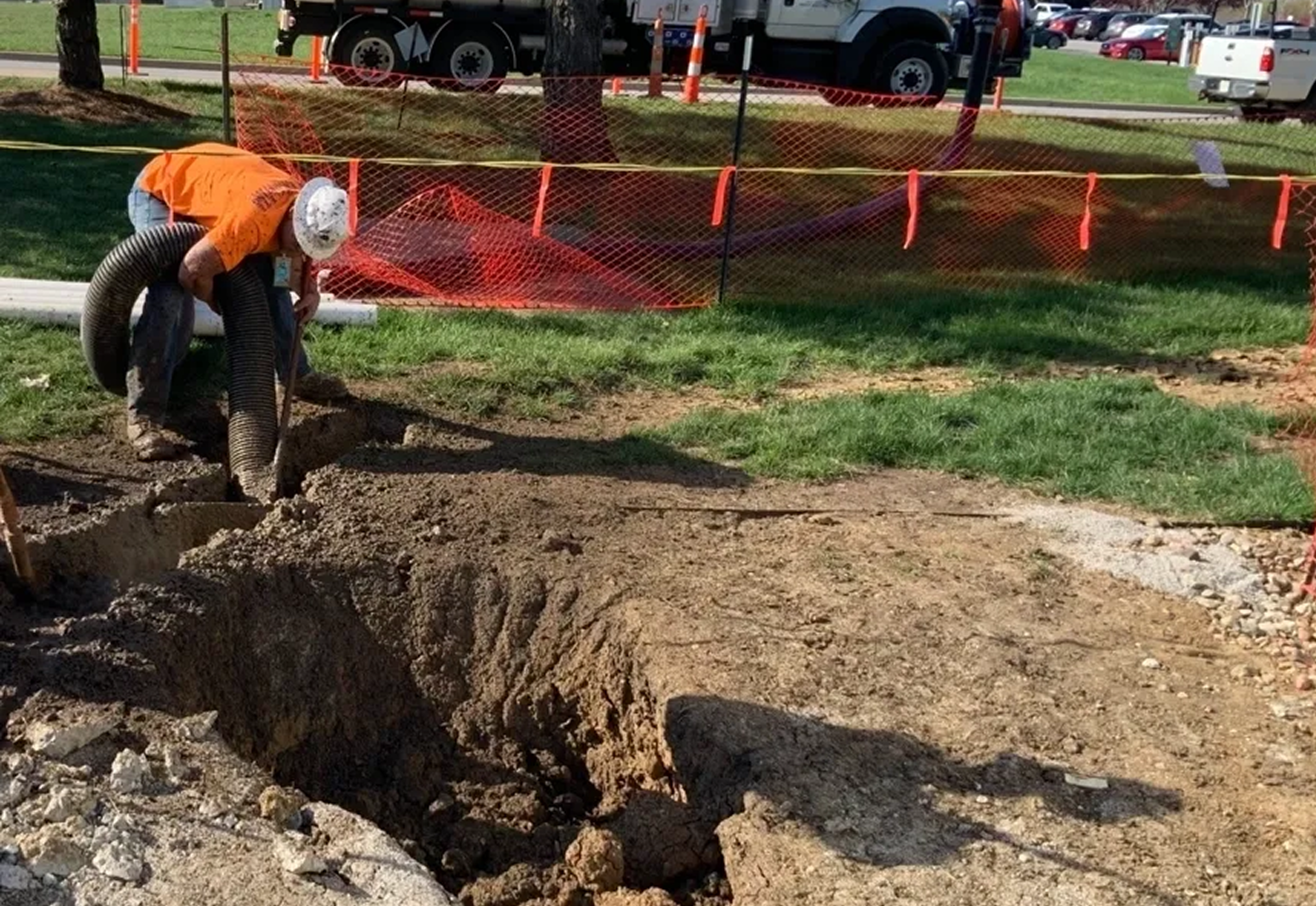 Worker using hose on construction site